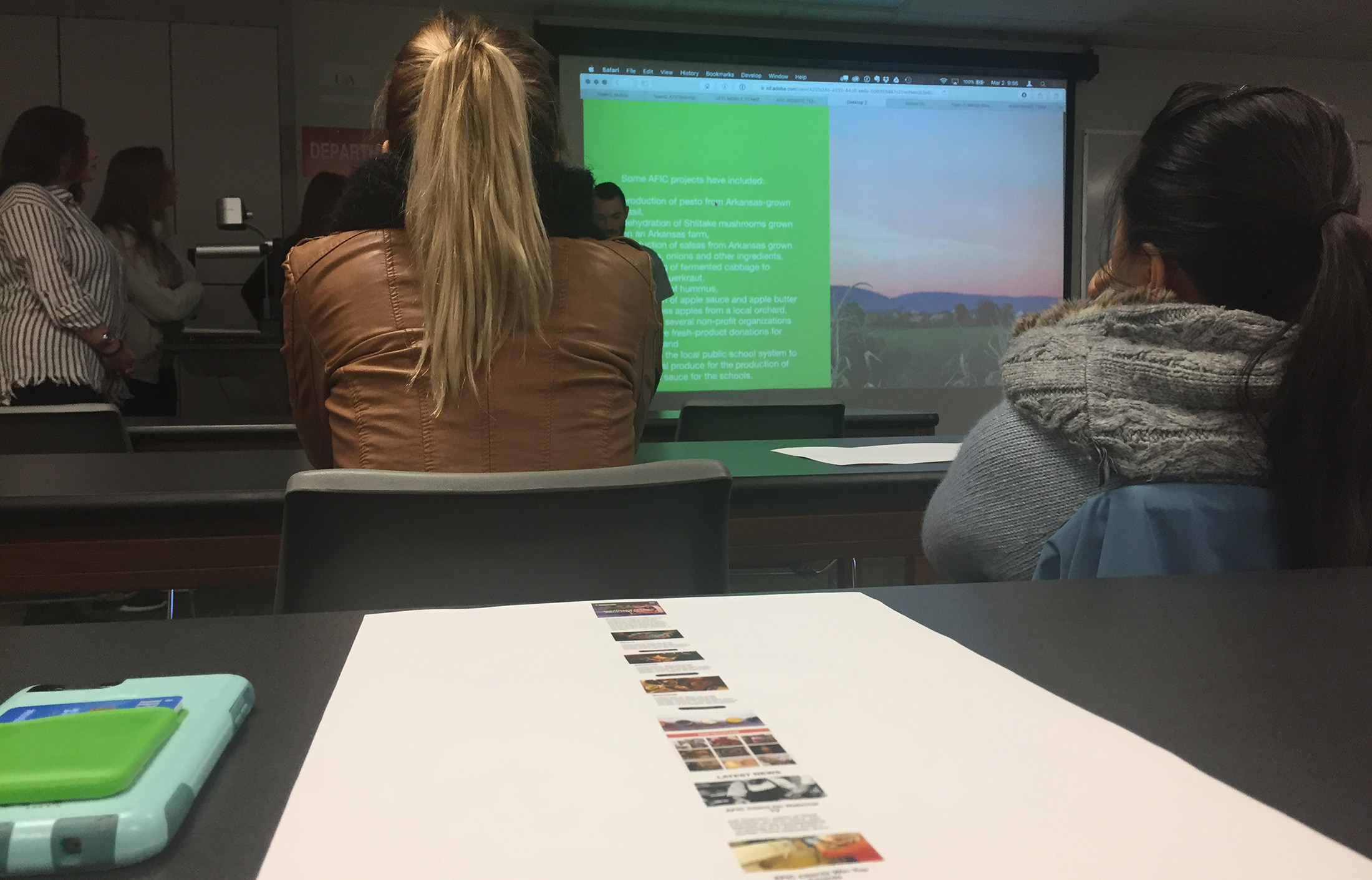 Students presenting web final projects to a class client